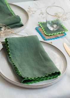 a table set with green napkins and silverware