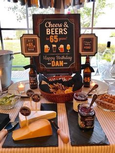 a table topped with cheese and beer next to a sign that says cheers & beers