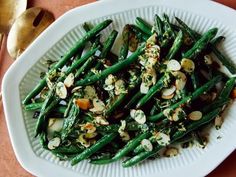 a white plate topped with green beans and nuts