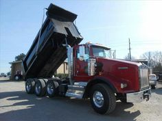 a red dump truck parked in a parking lot