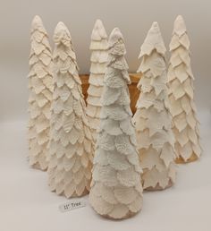 several white ceramic trees are lined up on a table