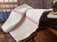 a stuffed animal sitting on top of a wooden chair next to a blanket and pillow