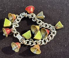 a close up of a bracelet with bells and chains on a carpeted surface,