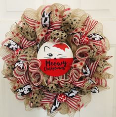 a red and white christmas wreath with an image of a cat that says merry christmas