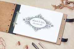 a wedding guest book on a table with pen, ring binder and other items