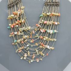 Twenty strands of beautiful glistening silvery seed beads and pastel shell piece.  The result is a light, summery bohemian look making a big statement.  This lovely vintage bib necklace is unmarked and has a hook closure.  It presents in very good condition - there is a small metal bead by the connector bar missing.  It doesn't case any issues and is not easily noticeable.  The wearable length is 17 inches long and it measures about 5-6 inches at the widest part. Metal Bead, Bohemian Look, Bohemian Necklace, Shell Jewelry, Multi Strand Necklace, Bib Necklace, Summer Jewelry, Jewelry Vintage, Strand Necklace