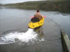 a man riding on the back of a yellow kayak