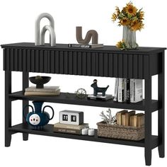 a black shelf with books and vases on it