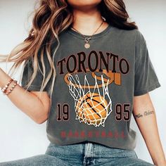 "Comfort Colors Toronto Basketball Shirt, Toronto Basketball Sweatshirt, Vintage Style Toronto Basketball shirt, Toronto Basketball fan Gift -Please check Color and Size Charts before placing the order. You can find them in the listing's photos (Depending on what device you are viewing this listing colors may vary slightly). -Returns and exchanges are accepted only if there are defects \"No Extra Costs\" We create custom t-shirts with great designs for everyone's liking. If you don't find the size or color you would like, please message us and we will be happy to  accommodate! Comfort Colors Toronto Basketball Shirt, Toronto Basketball Sweatshirt, Vintage Style Toronto Basketball shirt, Toronto Basketball fan Gift PRODUCT T-shirt Comfort Colors® 1717     Medium fabric (6.1 oz/yd² (206.8 g/ Sports Fan Tops With Sublimation Print For College, Trendy Sports Season Graphic Print Tops, Trendy Crew Neck Tops For Sports Season, Trendy Graphic Print Tops For Sports Season, Gray Fan Apparel Tops For Sports Events, Gray Crew Neck Top For Sports Events, Gray Screen Print Tops For College, Sports Fan Letter Print Tops For Streetwear, Gray Crew Neck Top For Team Spirit