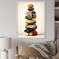 a poster with rocks stacked on top of each other in a living room next to a lamp