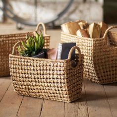 two woven baskets with plants in them on the floor