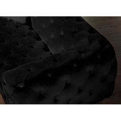 a black couch sitting on top of a wooden floor