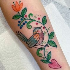 a small bird sitting on top of a tree branch with leaves and flowers around it