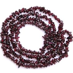 a strand of red glass beads on a white background