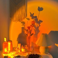 a table topped with candles and flowers next to a vase filled with flowers on top of a table