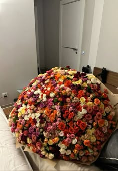 a large bouquet of flowers on top of a bed