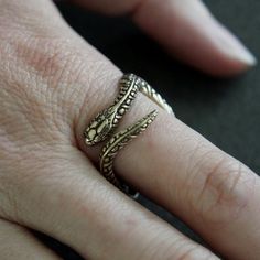 This beautiful garter snake ring is made of silicon bronze with a burnished oxidized finish to enhance the finely carved details. He is 3/4" at the widest point but does not impede finger movement because all the curves are in the right places. This little fellow is available from a size 4 to 13.ALTERNATIVE STYLES:I make a variety of different rings in a number of finishes to suit all styles, tastes and pocketbooks, check them out here:  http://www.etsy.com/shop/mrd74?section_id=7205630MOON RAVE Unique Engraved Brass Rings, Engraved Brass Rings, Vintage Jewelry With Oxidized Finish Open Ring, Vintage Oxidized Open Ring Jewelry, Vintage Open Ring Jewelry With Oxidized Finish, Antique Hand Cast Jewelry Ring, Antique Bronze Hand Cast Ring, Adjustable Bronze Metal Ring, Engraved Brass Open Ring Jewelry