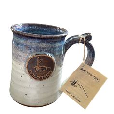 a blue and white mug with a tag on it