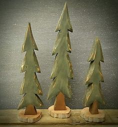 three wooden christmas trees sitting on top of a table