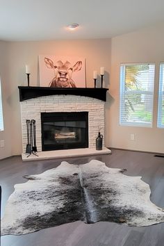 a living room with a fireplace and cow hide rug