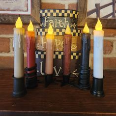 five lit candles sitting on top of a wooden table