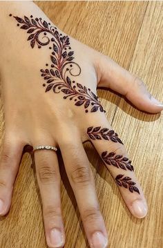 a woman's hand with a henna tattoo on it