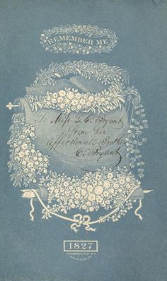 an old blue book with white flowers and vines on the cover, which is written in cursive writing