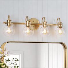 a bathroom vanity light with three bulbs on the side and a large mirror above it