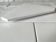 white ceramic tiles are arranged on top of each other