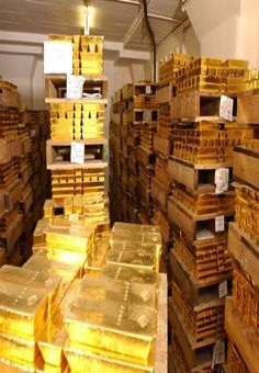 stacks of gold bars are stacked on top of each other in a storage room with tags hanging from the ceiling