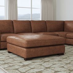 a living room with a large sectional couch and rug in front of the window,