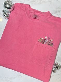 Experience the beauty of nature with our Flower Garden Pocket T-shirt in Crunchberry Pink. This stunning design is embroidered on high-quality Comfort Colors t-shirts for a soft and comfortable fit. Perfect for adding a touch of color to your wardrobe and showing off your love for nature. Details: - Brand: Comfort Colors-100% cotton - Color: Crunchberry Pink - Embroidered design **Please see additional photos for sizing and care instructions. Vinyl Flowers, Pink T Shirts, Nature Details, Embroidered Apparel, Embroidered Pocket, Embroidered Clothes, Pink Tshirt, Embroidered Tshirt, Pocket Tshirt