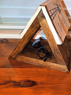 a pair of glasses sitting on top of a wooden shelf