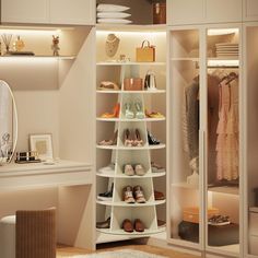 a white closet with shoes and other items on shelves in front of a mirror that is lit up