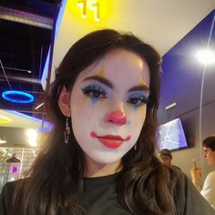 a woman with clown makeup is posing for the camera