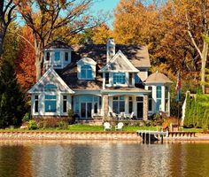 a large white house sitting on top of a lake