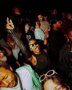 a group of people standing around each other in a room with one person holding an electric guitar