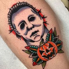 a close up of a person's arm with a tattoo on it and a pumpkin