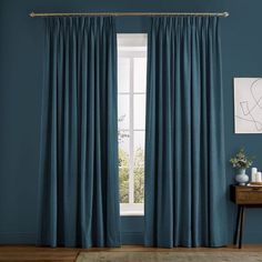 a living room with blue walls and curtains