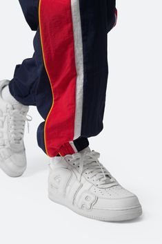 the Nylon Track Pants are designed with a custom-developed nylon fabric, multi color panelling details with contrast piping, and finished with ribbing at the waist and leg opening. details relaxed fit 100% nylon model is 6’1, 160 lbs and wears a size medium Nylon Track Pants, Layered Hoodie, Contrast Piping, Denim Flares, Nylon Fabric, Grey Hoodie, Red White Blue, Flannel Shirt, Black Hoodie