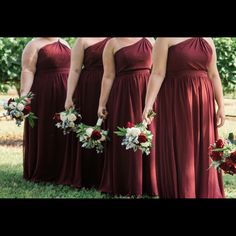 the bridesmaids are holding their bouquets in their hands and wearing red dresses