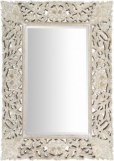 an ornately carved mirror is shown against a white background, with flowers and leaves on the frame