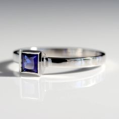 A square/princess cut is set in a tapered bezel. Petite and low profile. Band is approximately 2x1mm 4mm princess/square cut dark blue Chatham sapphire center stone Made in platinum Ring Size 7 Shiny finish Contact us if you are interested in having this ring resized before shipping. Formal Sapphire Ring With Princess Cut Solitaire, Elegant Square-cut Sapphire Ring In Sterling Silver, Modern Sapphire Ring With Bezel Setting For Formal Events, Classic Rectangular Lab-created Sapphire Ring, Elegant White Gold Sapphire Ring With Rectangular Shape, Elegant White Gold Sapphire Ring Rectangular, Elegant Rectangular Sapphire Ring In White Gold, Elegant White Gold Rectangular Sapphire Ring, Formal Sapphire Square Cut Rings