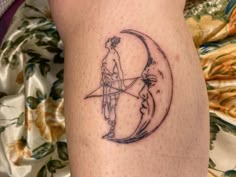 a tattoo on the leg of a person with a bow and arrow in front of a half moon