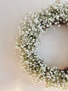 a wreath with white flowers is hanging on the wall