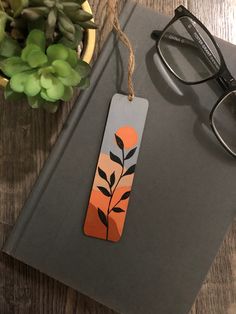 a pair of glasses sitting on top of a book next to a plant and eyeglasses