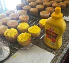 cupcakes and muffins are on the counter next to a bottle of orange juice