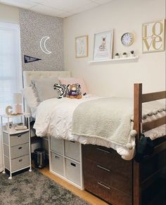 a bedroom with a bed, dressers and pictures on the wall