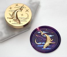 a purple plate with a gold crescent and stars on it next to a small metal container