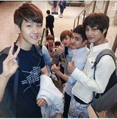 group of young men standing in front of an escalator giving the peace sign